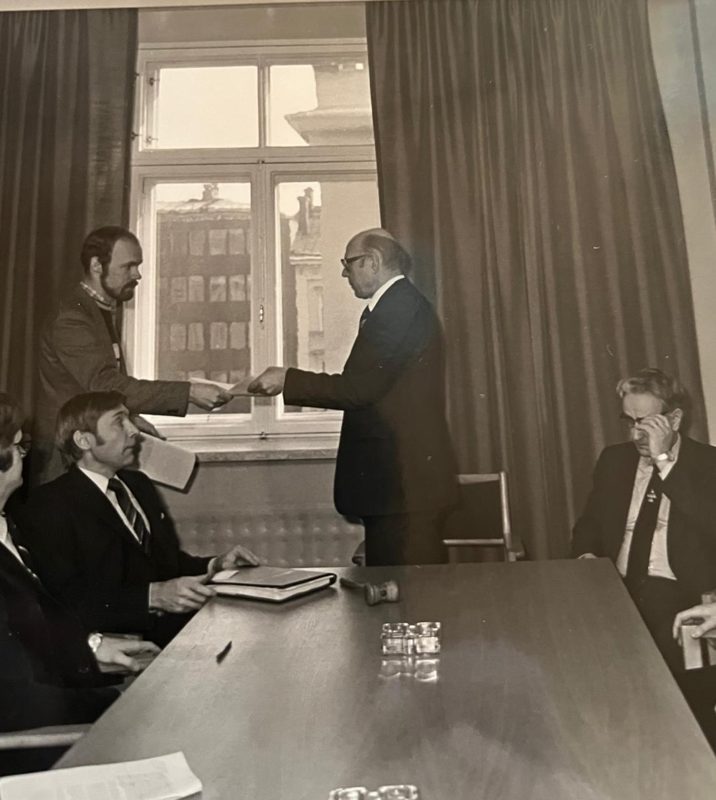 Arkistokuva: asiakirjan luovutus kokouksessa
